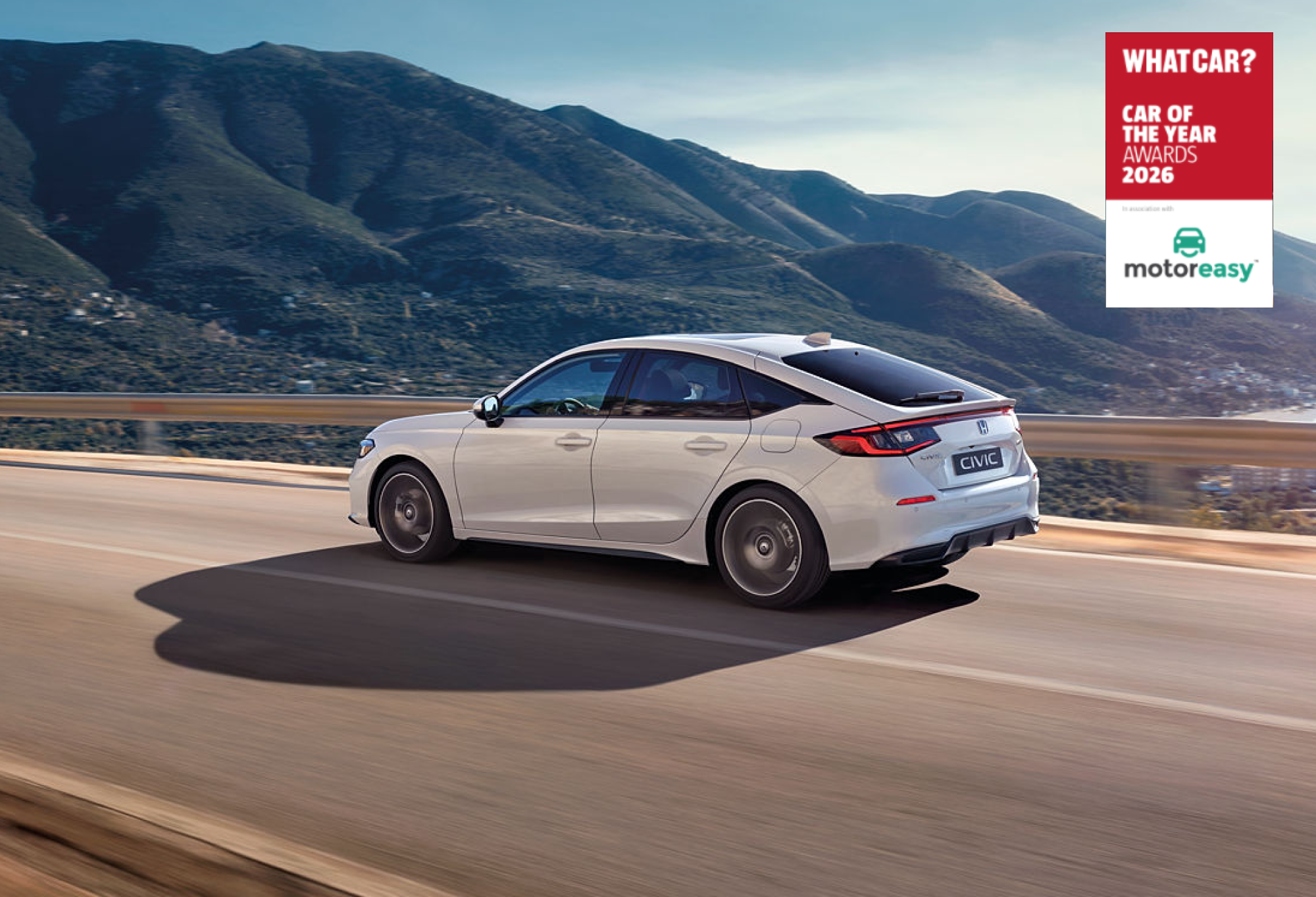 A white Honda Civic sedan driving on a mountain road with hills in the background. The image includes a \"What Car? Car of the Year Awards 2026\" logo in the top right corner.